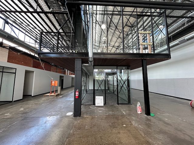 Large open plan office complex with state of the art mezzanine and floor to ceiling T-bar style windows masterfully fabricated by Harris Steel