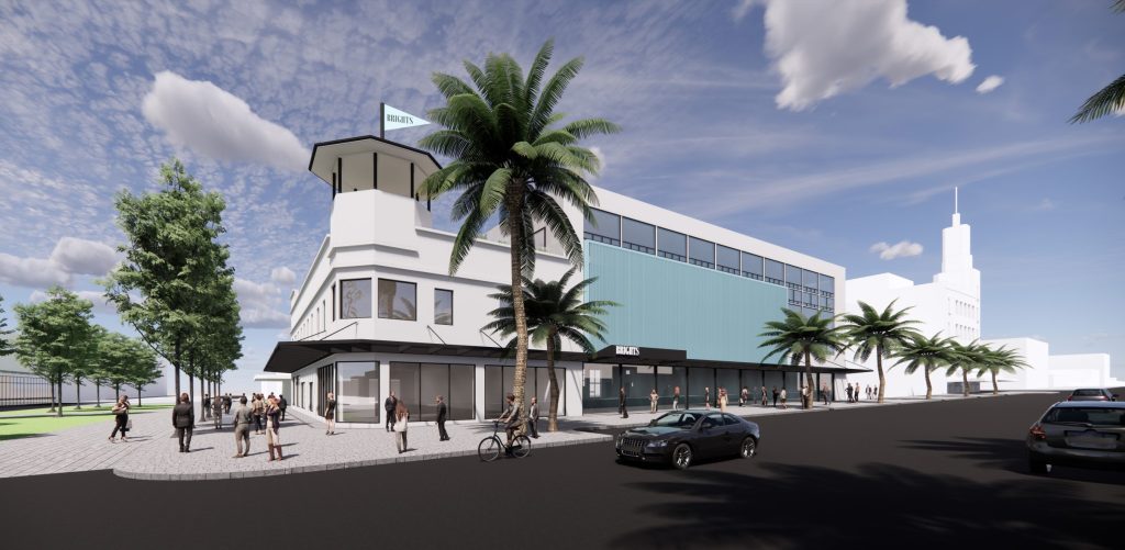Large white and blue corner building, long glass windows at street level with an awning over-head, street running in front of the building has a man on a bike and a black car driving past, a palm tree stands tall in front of the building. Brights & hitchcocks idea by Hamilton Property Group