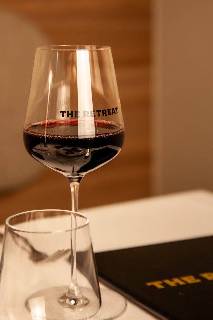 Geelong's newest French-inspired restaurant - The Retreat restaurant and bar. Red wine and menu on table.