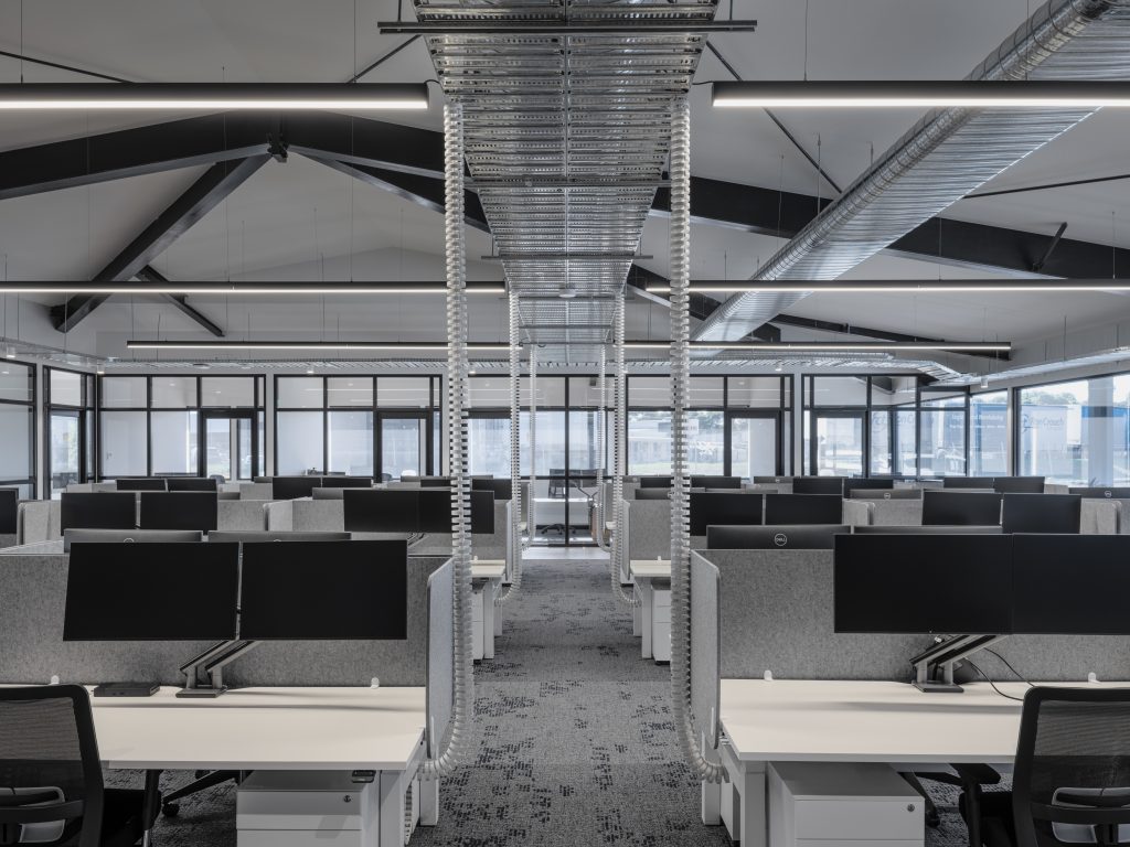 Office fit-out in Laverton North by Hamilton Group. Large open plan office space with white desks and monitors. 